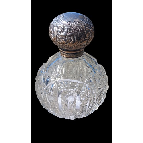 176 - A SILVER TOPPED CUT GLASS PERFUME BOTTLE