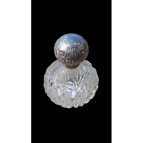 176 - A SILVER TOPPED CUT GLASS PERFUME BOTTLE