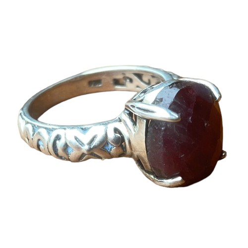 223 - AN ORNATE DESIGNER STYLE SILVER RING SET WITH A RED STONE