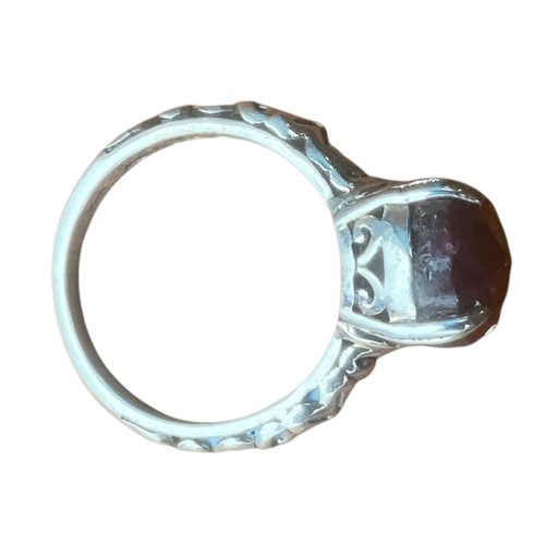 223 - AN ORNATE DESIGNER STYLE SILVER RING SET WITH A RED STONE