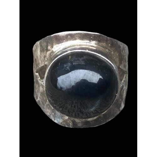 507 - A SILVER DESIGNER STYLE RING SET WITH AN UNUSAL BLACK STONE (BEATEN SILVER DESIGN)