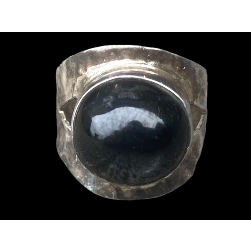 507 - A SILVER DESIGNER STYLE RING SET WITH AN UNUSAL BLACK STONE (BEATEN SILVER DESIGN)