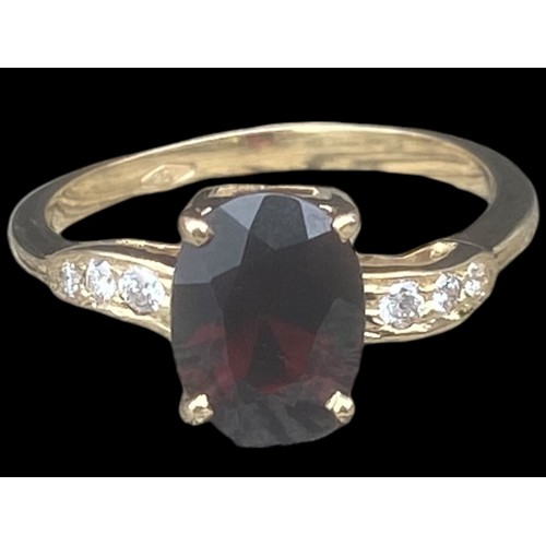 577D - 18ct YELLOW GOLD OVEL RED STONE RING SET IN 4 CLAWS WITH 3 DIAMONDS TO EACH SHOULDER SIZE M 2.70gms