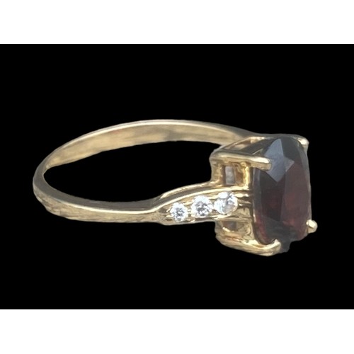 577D - 18ct YELLOW GOLD OVEL RED STONE RING SET IN 4 CLAWS WITH 3 DIAMONDS TO EACH SHOULDER SIZE M 2.70gms