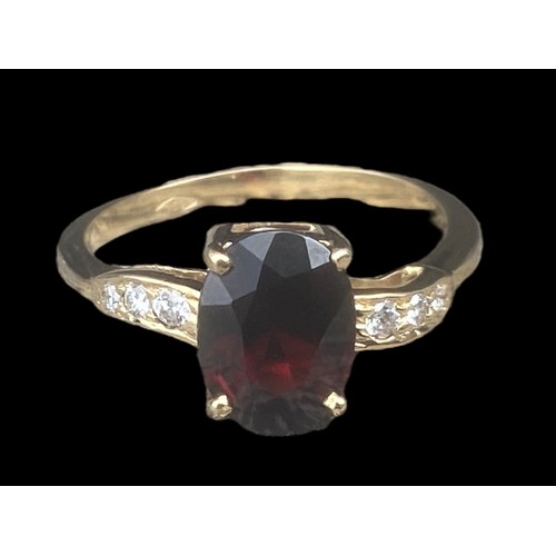 577D - 18ct YELLOW GOLD OVEL RED STONE RING SET IN 4 CLAWS WITH 3 DIAMONDS TO EACH SHOULDER SIZE M 2.70gms