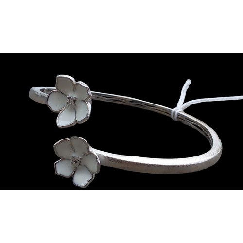 195 - A SILVER BANGLE WITH FLOWER SETTING (DIAMOND CENTRE)