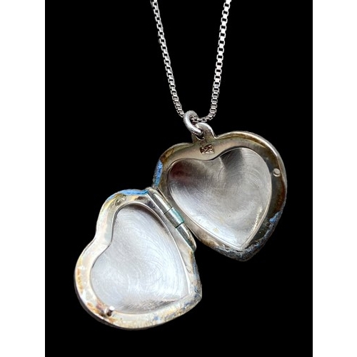 272 - A SILVER HEART LOCKET ON A LONG SILVER CHAIN