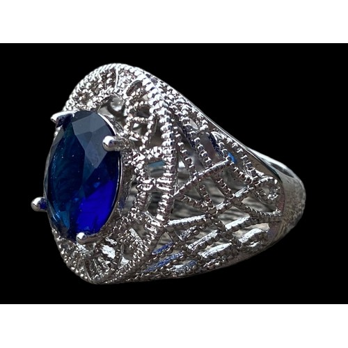 529 - AN ORNATE SILVER OPENWORK RING SET WITH BLUE STONE