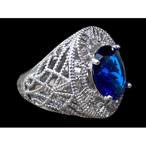 529 - AN ORNATE SILVER OPENWORK RING SET WITH BLUE STONE