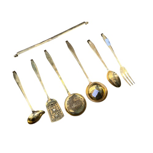 74 - A BRASS OVER COPPER 6 PIECE HANGING UTENILS SET WITH RACK