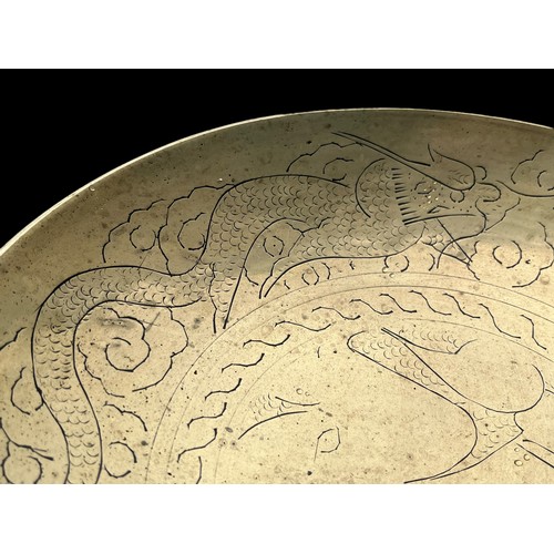 148 - A CHINESE BRASS BOWL DEPICITING DRAGONS APPROX 26CMS DIA