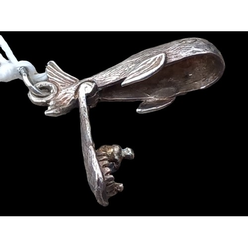 211 - AN ARTICULATED SILVER JONA & THE WHALE PENDANT/CHARM