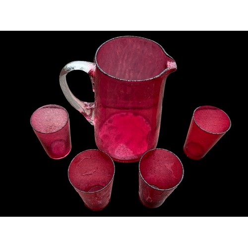 435 - A QUALITY RUBY GLASS JUG WITH CLEAR GLASS HANDLE ALONG WITH 4 RUBY DRINKING GLASS (LEMONADE SET)