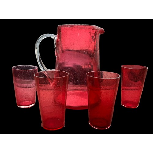 435 - A QUALITY RUBY GLASS JUG WITH CLEAR GLASS HANDLE ALONG WITH 4 RUBY DRINKING GLASS (LEMONADE SET)