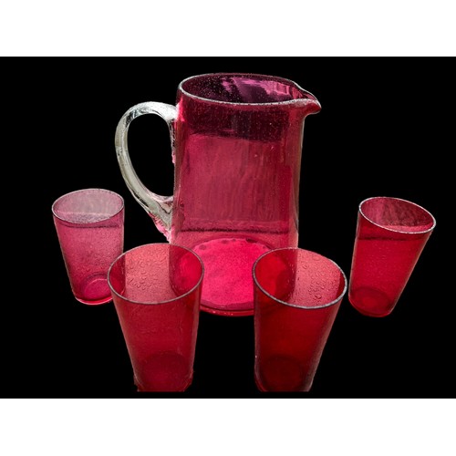 435 - A QUALITY RUBY GLASS JUG WITH CLEAR GLASS HANDLE ALONG WITH 4 RUBY DRINKING GLASS (LEMONADE SET)