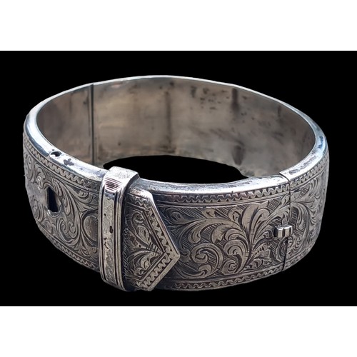 551 - A DECORATIVE BELT & BUCKLE HINGED BANGLE 26.5G (SLIGHT DAMAGE)