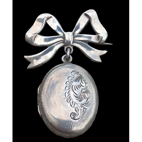 554 - AN UNUSAL SILVER LOCKET & BOW BROOCH