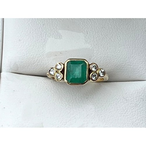 627 - AN 18ct GOLD EMERALD AND DIAMOND RING SQUARE EMERALD CUT WITH 3 BRILLIANT CUT DIAMONDS EACH SIDE SIZ... 