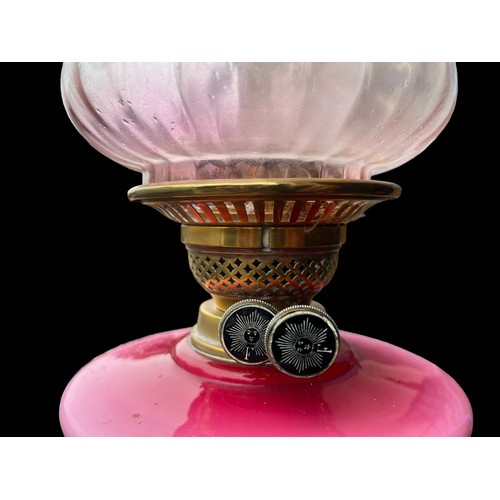 657 - A PINK PORCELAIN HAND PAINTED OIL LAMP BOWL WITH ORNATE BRASS BASE AND NICELY SHAPED SHADE