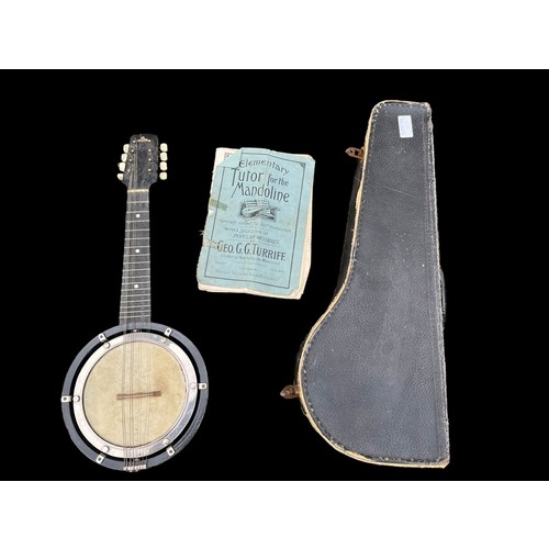 402 - A SMALL VINTAGE BANJO IN CASE AND WITH A BOOK