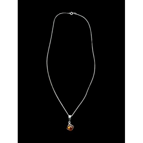 169 - A SILVER AND AMBER PENDANT ON A SILVER CHAIN