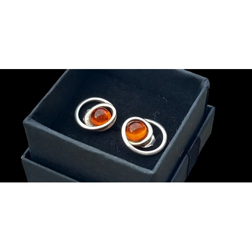 194 - A PAIR OF SILVER CIRCULAR SILVER EARRINGS SET WITH AMBER