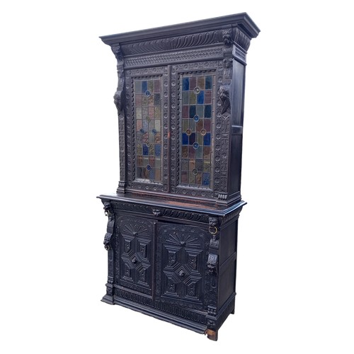 474 - A STUNNING ANTIQUE HEAVILY CARVED TALL IRISH BOOKCASE WITH STAINED GLASS PANELS DECORATIVLY CARVED W... 