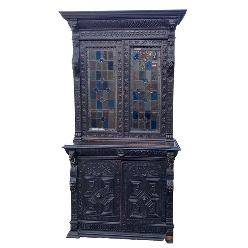 474 - A STUNNING ANTIQUE HEAVILY CARVED TALL IRISH BOOKCASE WITH STAINED GLASS PANELS DECORATIVLY CARVED W... 