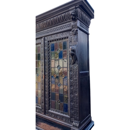 474 - A STUNNING ANTIQUE HEAVILY CARVED TALL IRISH BOOKCASE WITH STAINED GLASS PANELS DECORATIVLY CARVED W... 