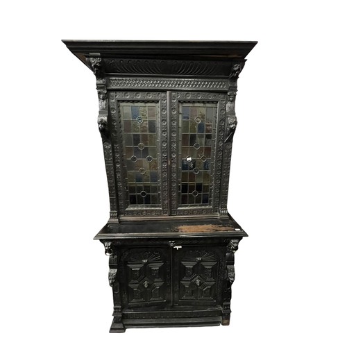 474 - A STUNNING ANTIQUE HEAVILY CARVED TALL IRISH BOOKCASE WITH STAINED GLASS PANELS DECORATIVLY CARVED W... 