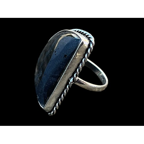 496 - AN ORNATE SILVER RING SET WITH A BLACK STONE