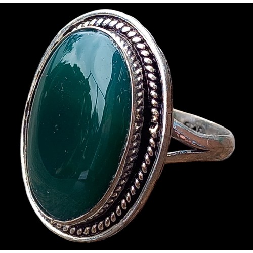 518 - A LARGE ORNATE SILVER RING SET WITH A LARGE GREEN STONE