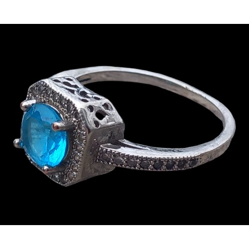 226 - A SILVER GEM SET RING WITH A BLUE STONE