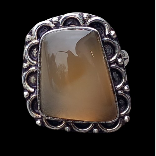 168 - A SHAPED ORNATE SILVER RING SET WITH A SEMI-PRECIOUS STONE