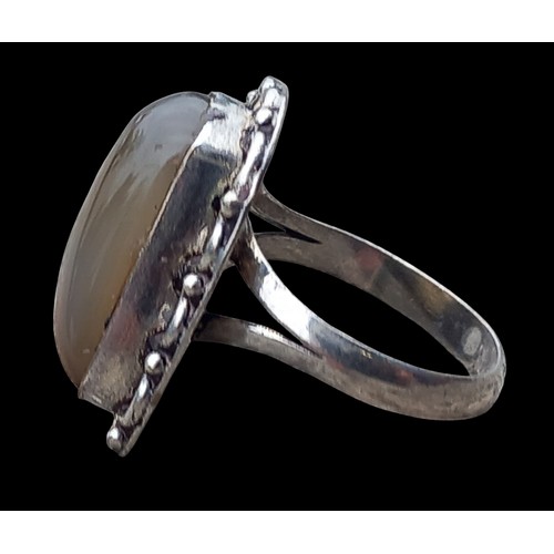 168 - A SHAPED ORNATE SILVER RING SET WITH A SEMI-PRECIOUS STONE