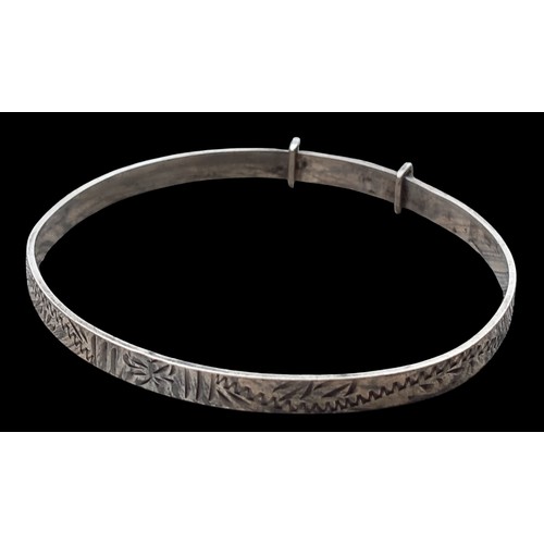 170 - AN ORNATE SILVER EXPANDING BANGLE ENGRAVED