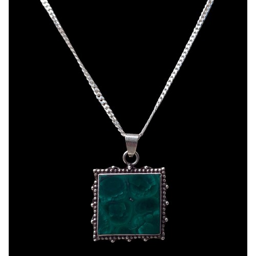 206 - AN ORNATE SILVER MOUNTED PENDANT SET WITH NATURAL GREEN STONE ON A FLATLINK SILVER CHAIN