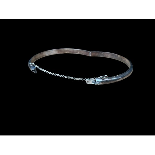 217 - A SILVER CURVED BANGLE WITH SAFETY CHAIN