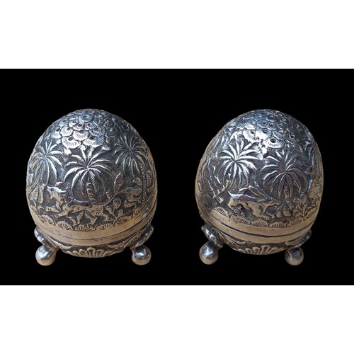 473 - A PAIR OF ORNATE EGG SHAPE CONDIMENTS ON TRIPOD FOOT