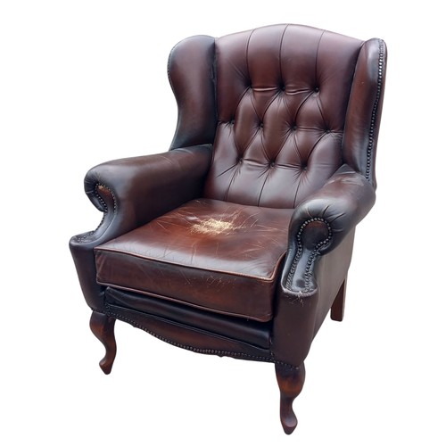 643 - A VERY NICELY SHAPED DARK BROWN LEATHER WINGBAK ARMCHAIR WITH BUTTON BACK ON QUEEN ANNE LEG