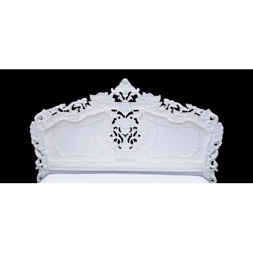 691 - AN AS NEW DOUBLE DRAWERED DIVAN BED WITH A HEAVILY CARVED PAINTED HEADBOARD