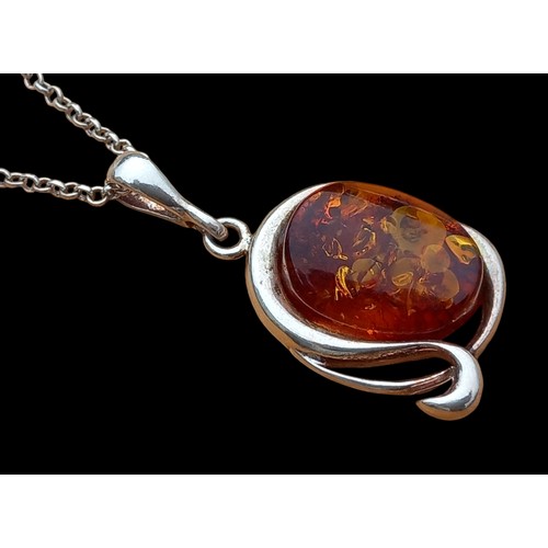 195 - AN AMBER AND SILVER PENDANT ON SILVER CHAIN