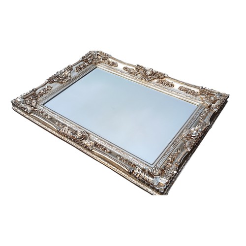 680C - A VERY ORNATE SILVER FRAMED MIRROR 35 x 46