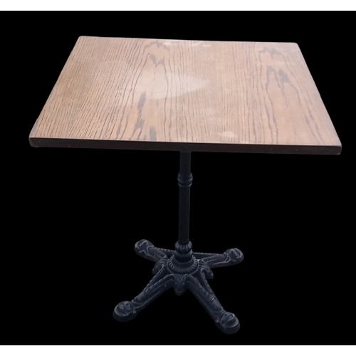 399 - A BISTRO TABLE ON AN ORNATE  CAST IRON BASE