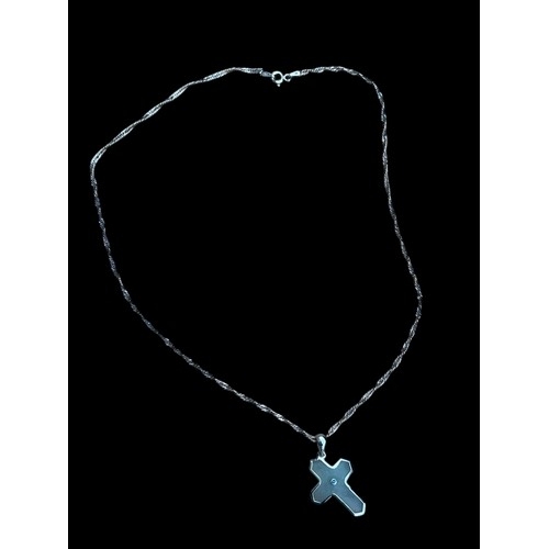 153 - A SILVER GEM SET JADE STYLE CROSS ON A SILVER CHAIN