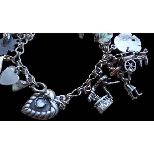 224 - A SILVER CHARM BRACELET COMPLETE WITH 17 QUALITY CHARMS