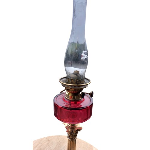 786 - A STUNNING SHAPED DARK RUBY BOWL OIL LAMP ON AN ORNATE BRASS PILLARED BASE COMPLETE WITH FUNNEL