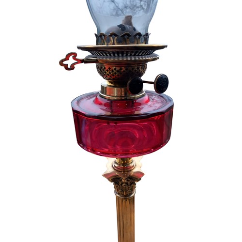 786 - A STUNNING SHAPED DARK RUBY BOWL OIL LAMP ON AN ORNATE BRASS PILLARED BASE COMPLETE WITH FUNNEL