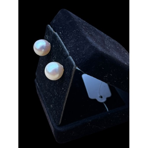 613 - A PAIR OF PEARL STUD EARRINGS ON 14ct WHITE GOLD STEMS