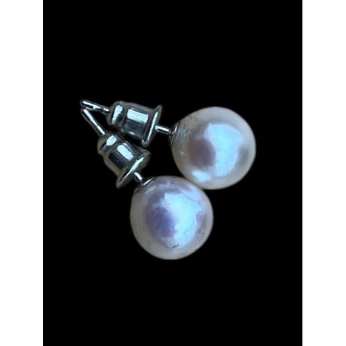 613 - A PAIR OF PEARL STUD EARRINGS ON 14ct WHITE GOLD STEMS